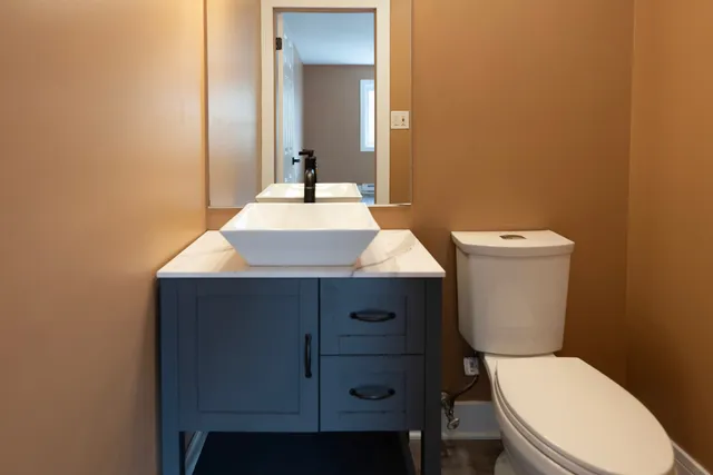 a bathroom with a toilet a sink and mirror
