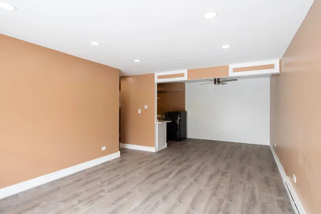 an empty room with wooden floor and entrance