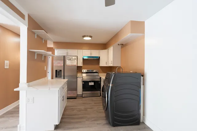 a kitchen with stainless steel appliances kitchen island granite countertop a refrigerator and a stove