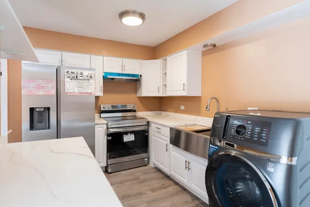 a kitchen with stainless steel appliances granite countertop a stove a refrigerator and a sink