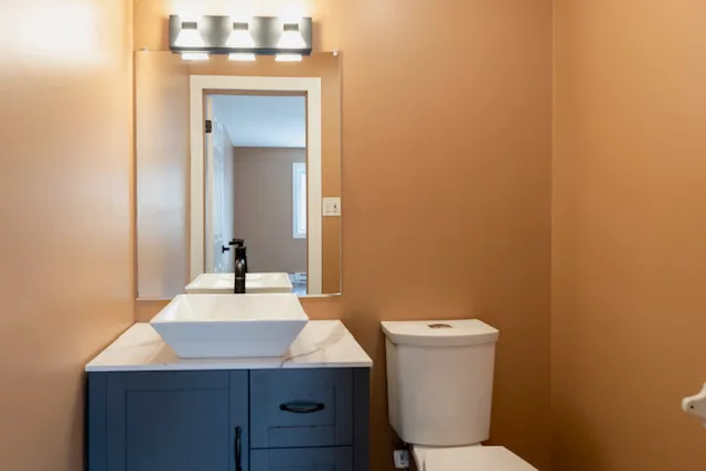 a bathroom with a sink a toilet and mirror