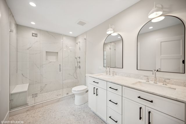a bathroom with a double vanity sink mirror double and shower