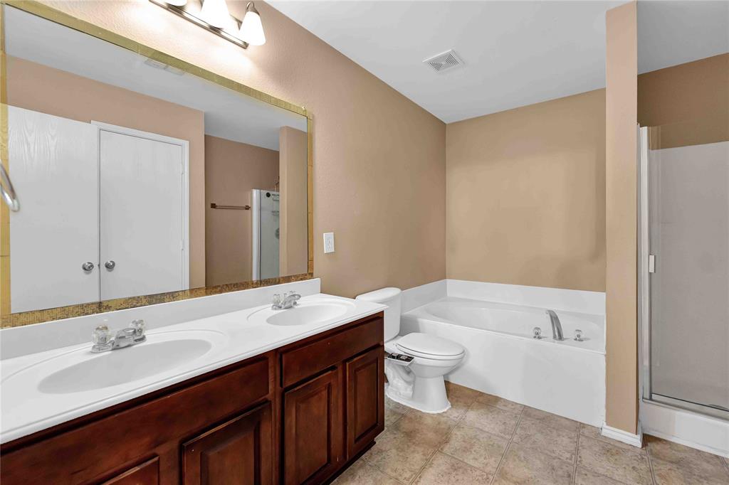 9517 George Washington Drive McKinney, TX 75072 - Photo 12 of 31 a bathroom with a double vanity sink and mirror with toilet