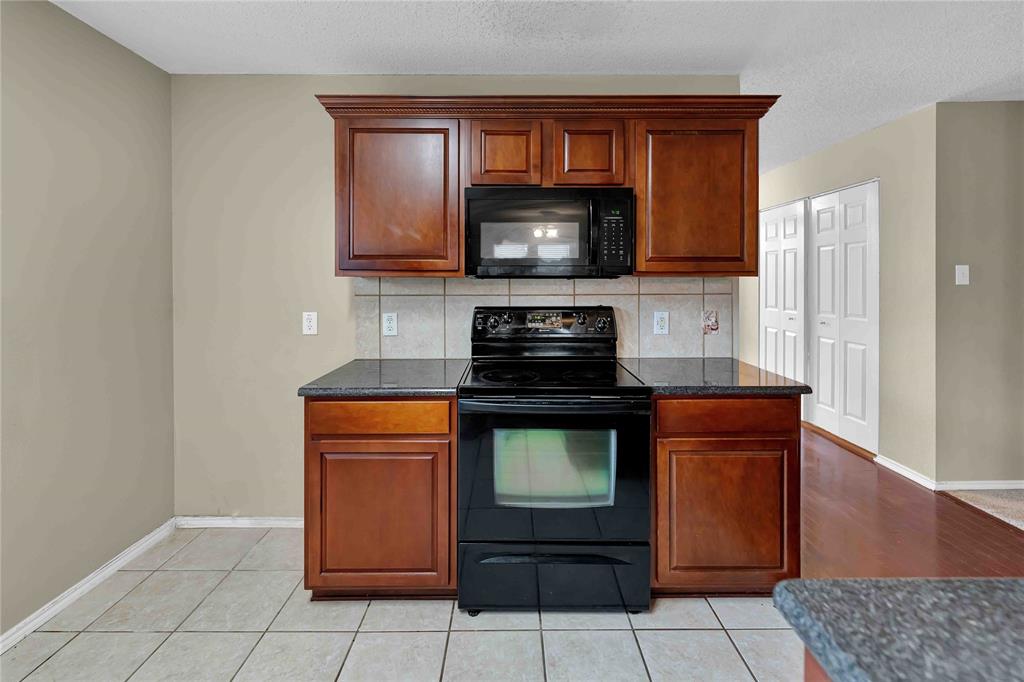 9517 George Washington Drive McKinney, TX 75072 - Photo 8 of 31 a kitchen with stainless steel appliances granite countertop a stove a microwave and a refrigerator