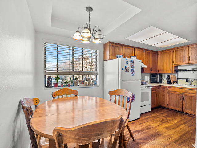 460 200 South Provo, UT 84606 - Photo 38 of 66 Dining area with dark wood-style floors, hanging lights, and a tray ceiling