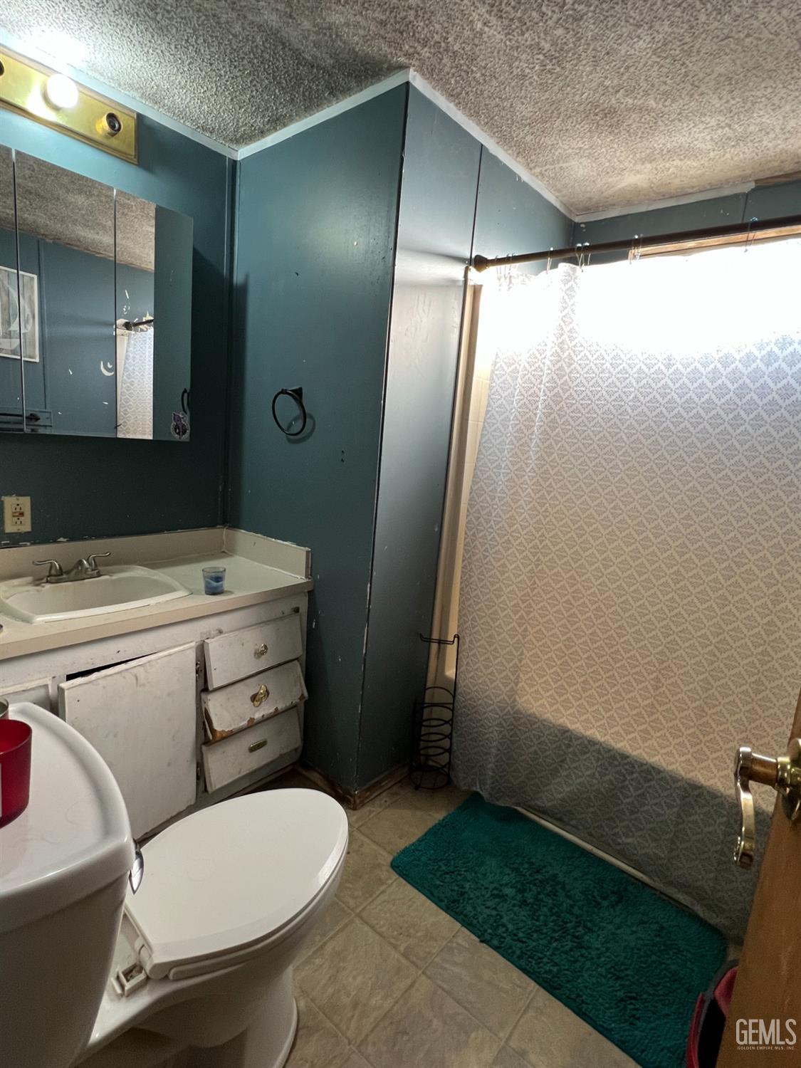 Undisclosed Address Bakersfield, CA 93309 - Photo 9 of 14 a bathroom with a toilet a sink and mirror