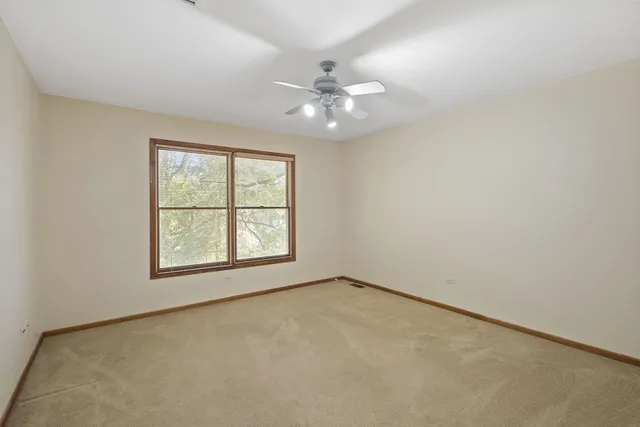 an empty room with a window and a fan