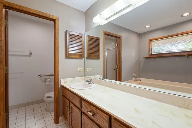 a spacious bathroom with a granite countertop sink toilet and shower