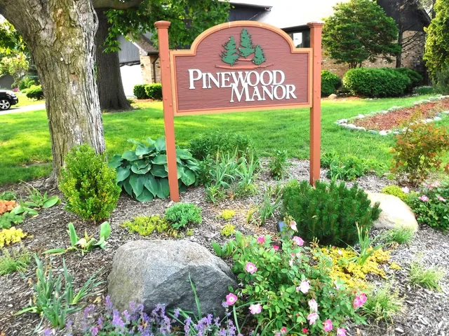 a sign that is sitting in front of flowers