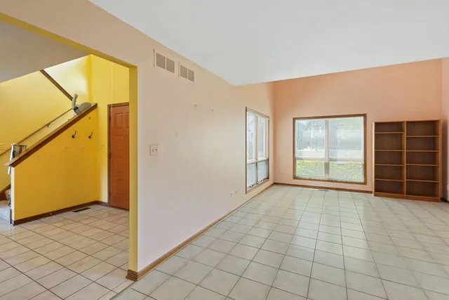 a view of an empty room with window and cabinet