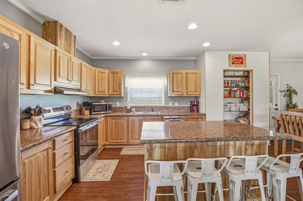 1262 Rosser Ranch Road Graham, TX 76450 - Photo 6 of 39 a kitchen with stainless steel appliances granite countertop a stove and cabinets