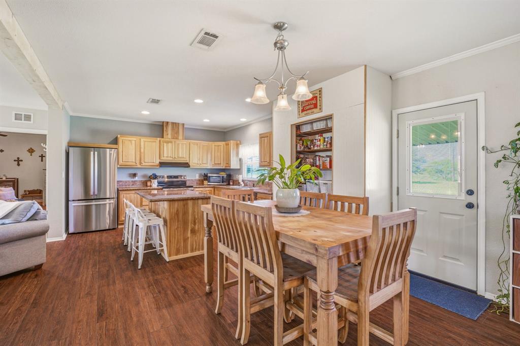 1262 Rosser Ranch Road Graham, TX 76450 - Photo 8 of 39 a view of a dining room and livingroom with furniture wooden floor a chandelier