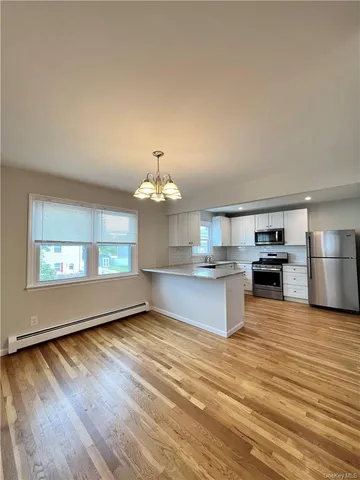 an open kitchen with kitchen island white cabinets and stainless steel appliances