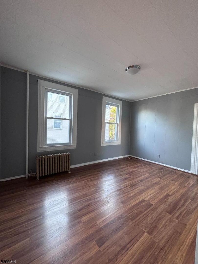 260 Pacific Street, Unit 2 Paterson, NJ 07503 - Photo 4 of 12 a view of an empty room with wooden floor and a window