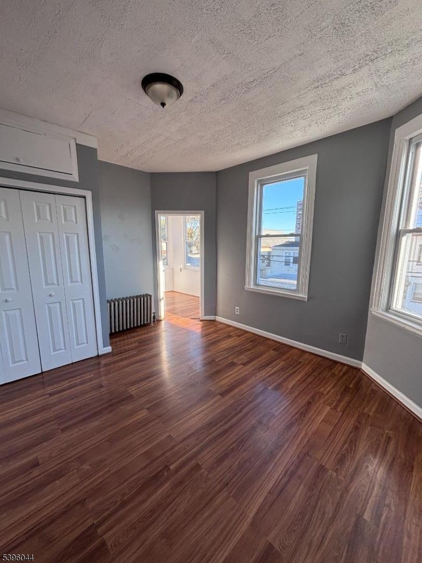 260 Pacific Street, Unit 2 Paterson, NJ 07503 - Photo 7 of 12 a view of an empty room with wooden floor and a window