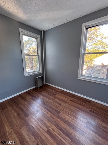 260 Pacific Street, Unit 2 Paterson, NJ 07503 - Photo 9 of 12 a view of an empty room with wooden floor and a window