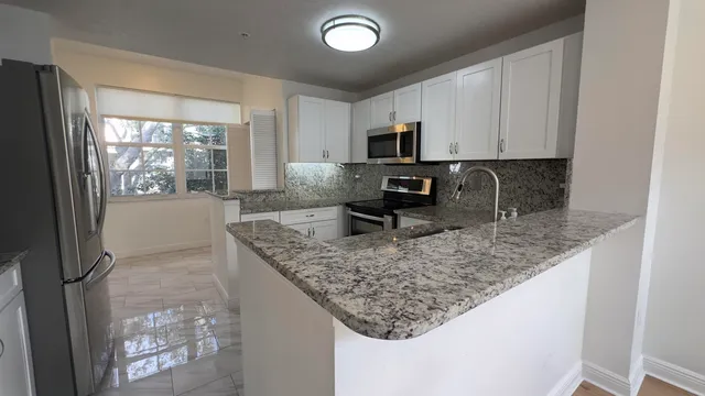 a kitchen with stainless steel appliances granite countertop a sink stove and microwave