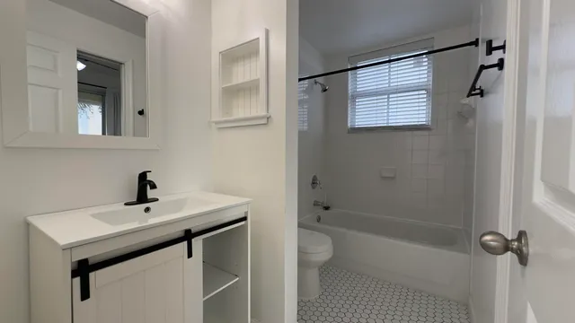 a bathroom with a sink a toilet and shower