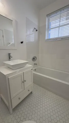 a bathroom with a sink a vanity and a bathtub