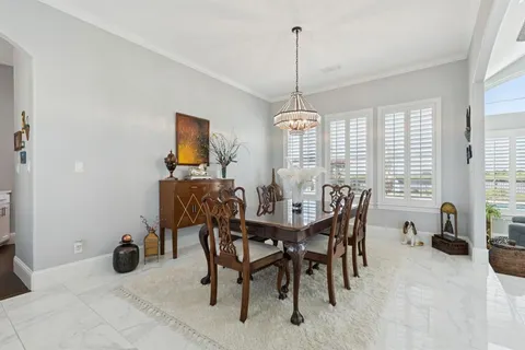 a view of a dining room and livingroom with furniture wooden floor a chandelier
