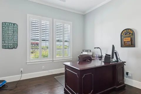 a view of a workspace with furniture and a window