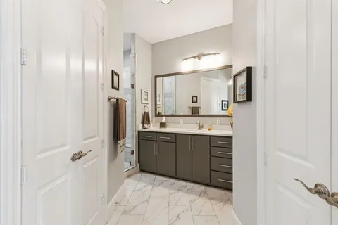 a bathroom with a double vanity sink a mirror and a shower