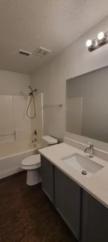 a bathroom with a double vanity sink a toilet and a bathtub