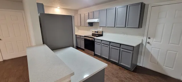 a kitchen with stainless steel appliances granite countertop a refrigerator and a stove top oven