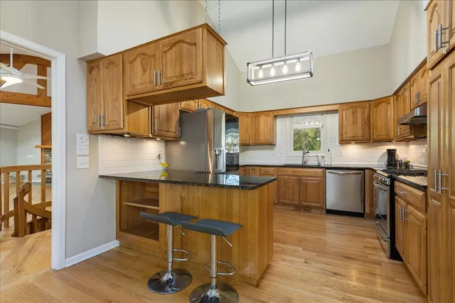 a kitchen with granite countertop a stove a refrigerator and wooden cabinets