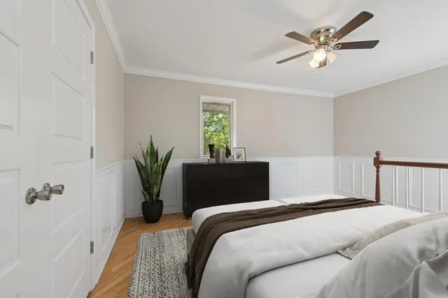 a bedroom with a large bed and a chandelier