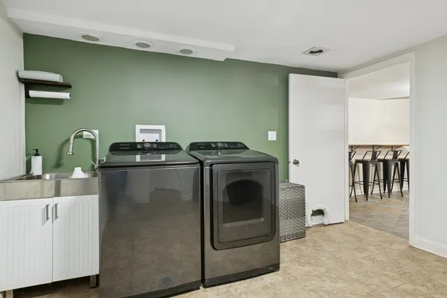 a utility room with sink dryer and washer