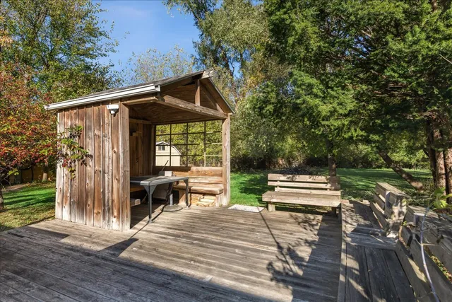 a backyard of a house with wooden floor and outdoor seating