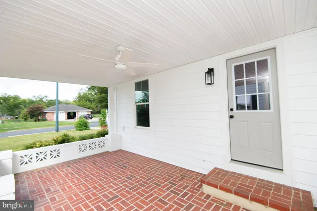 a view of an empty room with a window and hardwood