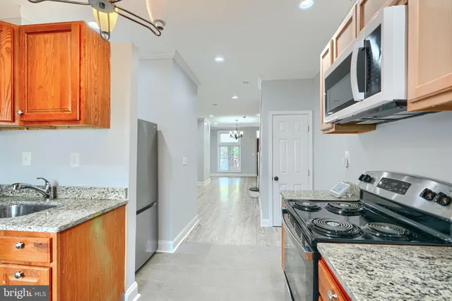a kitchen with stainless steel appliances granite countertop a stove and a sink