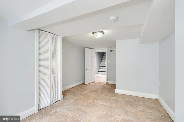 an empty room with closet and windows