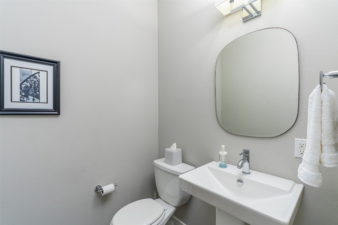 705 East 49th Street, Unit A Austin, TX 78751 - Photo 14 of 39 a bathroom with a toilet a sink and mirror