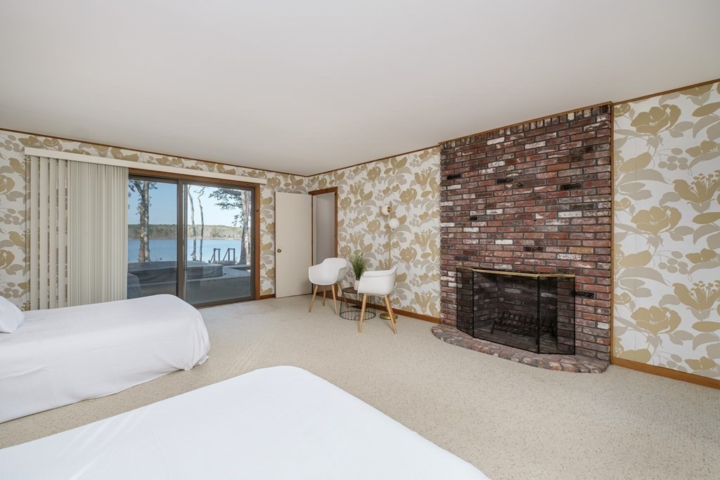 61 Tide Run Mashpee, MA 02649 - Photo 20 of 39 a bedroom with furniture and a fireplace