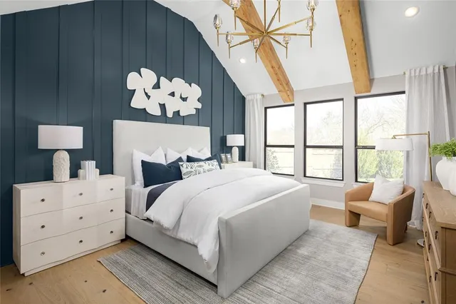 a bedroom with a large bed and a chandelier