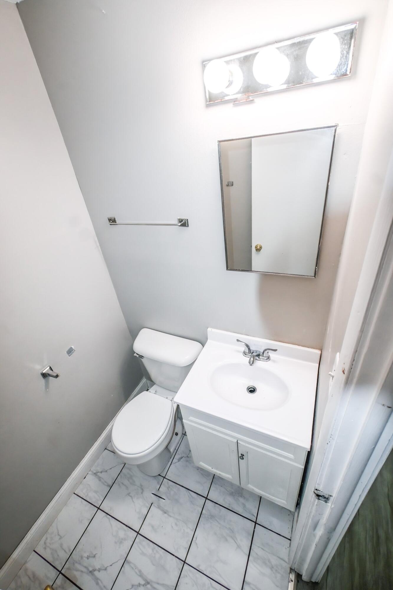 7828 Chestnut Avenue Hammond, IN 46324 - Photo 15 of 23 a white toilet sitting next to a bathroom sink