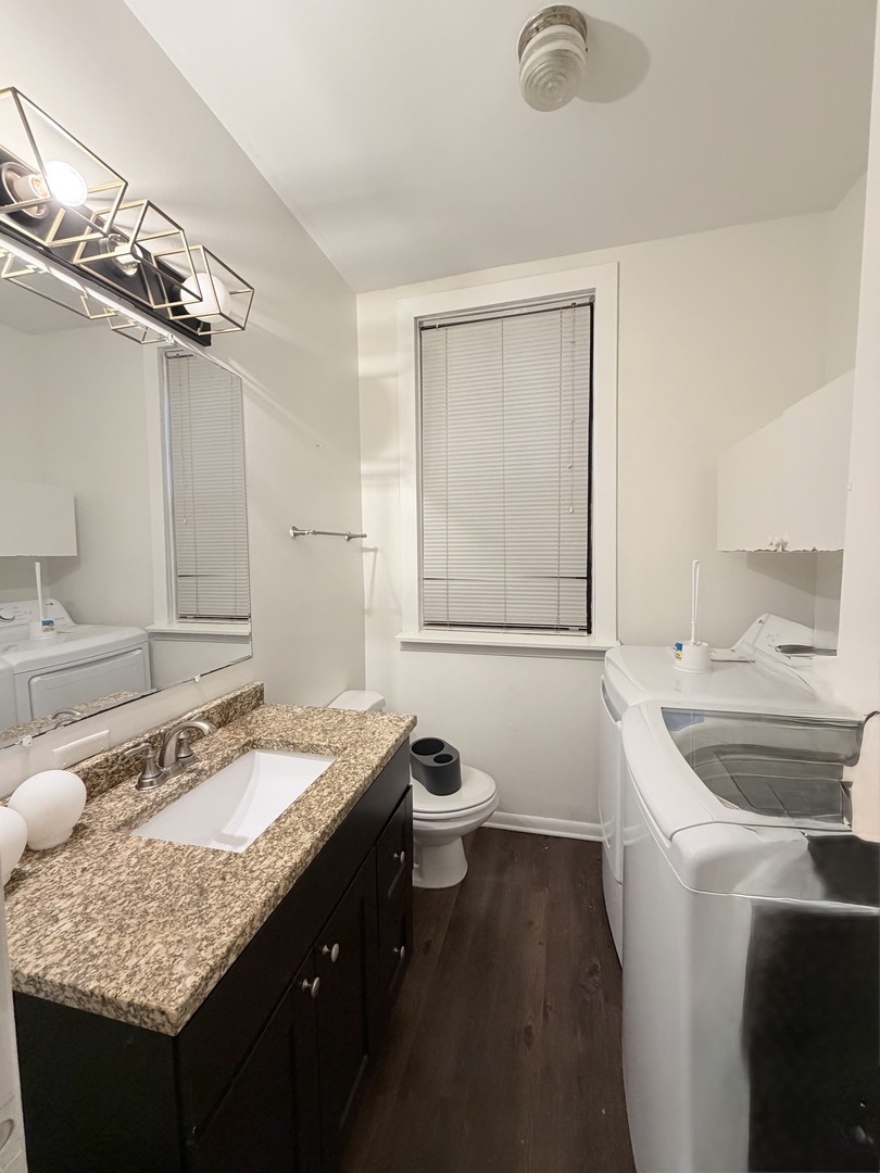 642 North Dearborn Street, Unit CH Chicago, IL 60654 - Photo 12 of 19 a bathroom with a granite countertop sink a mirror and a toilet