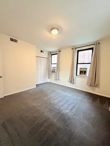 a view of an empty room with a window and fireplace
