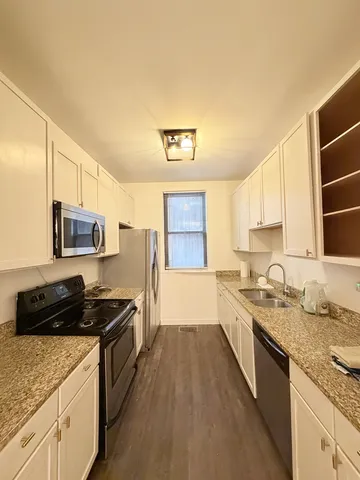 a kitchen with a sink stove top oven and microwave