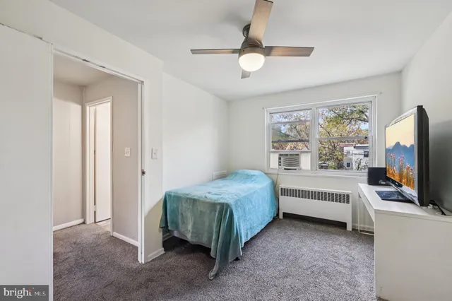 a room with a bed and a flat tv screen on dresser