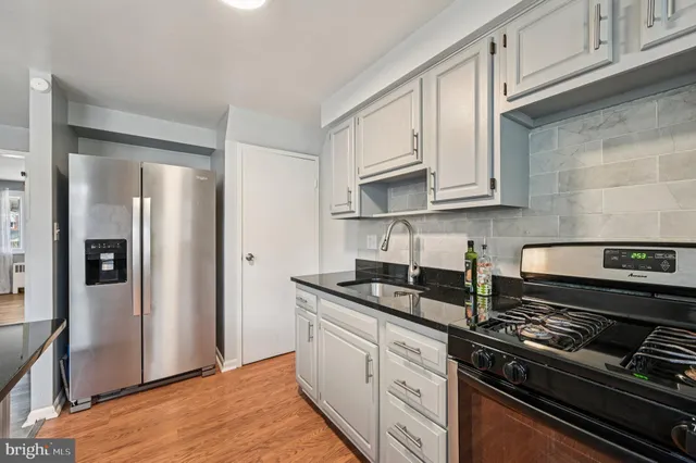 a kitchen with stainless steel appliances granite countertop a refrigerator stove and cabinets