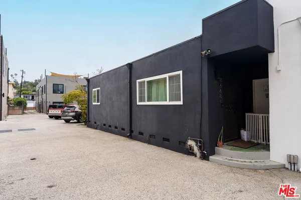 a view of a house with cars parked in front of it