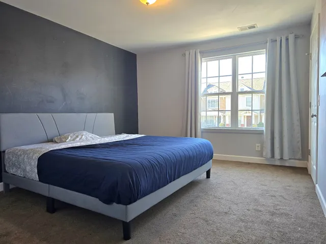 a bedroom with a bed lamp and window