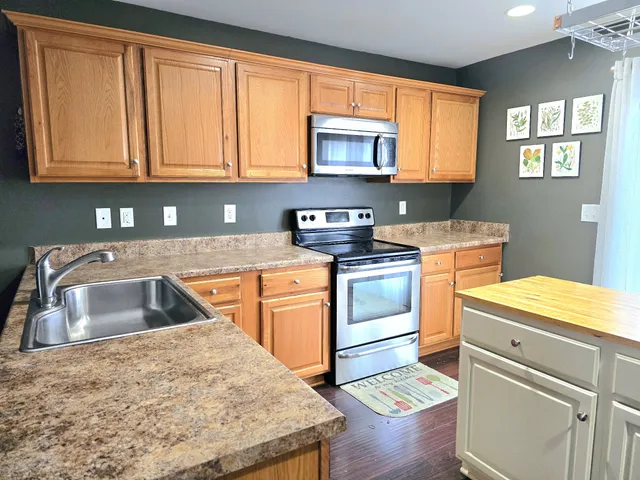 a kitchen with granite countertop a sink stove and cabinets