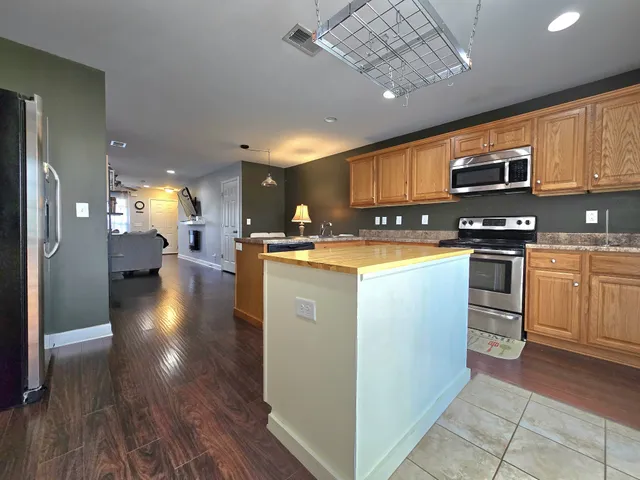 a kitchen with stainless steel appliances granite countertop a sink a stove and a refrigerator