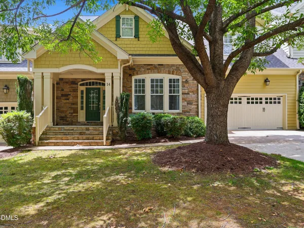a front view of a house with a tree