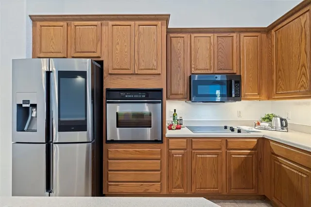 a kitchen with stainless steel appliances granite countertop a refrigerator and a sink